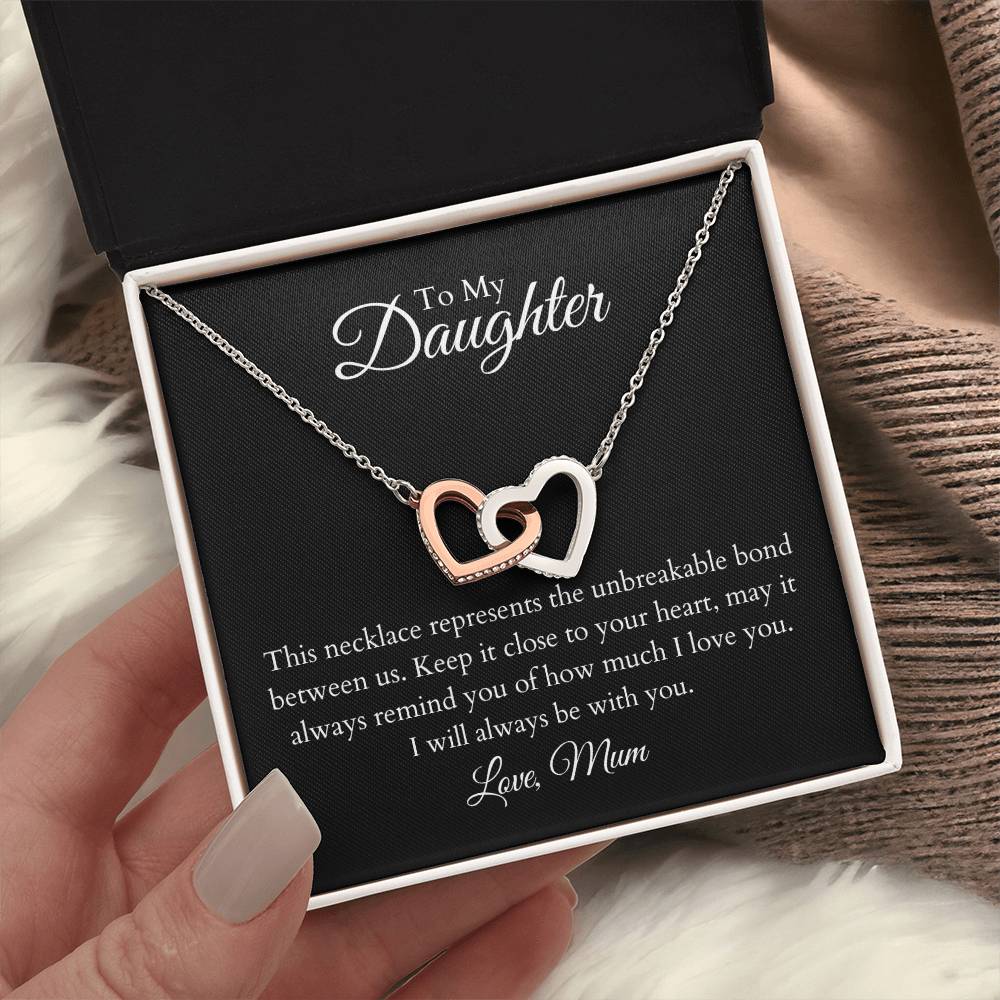 To My Daughter, two lovely interlocking heart pendants embellished with CZ crystals. High quality polished surgical steel and rose gold finish.