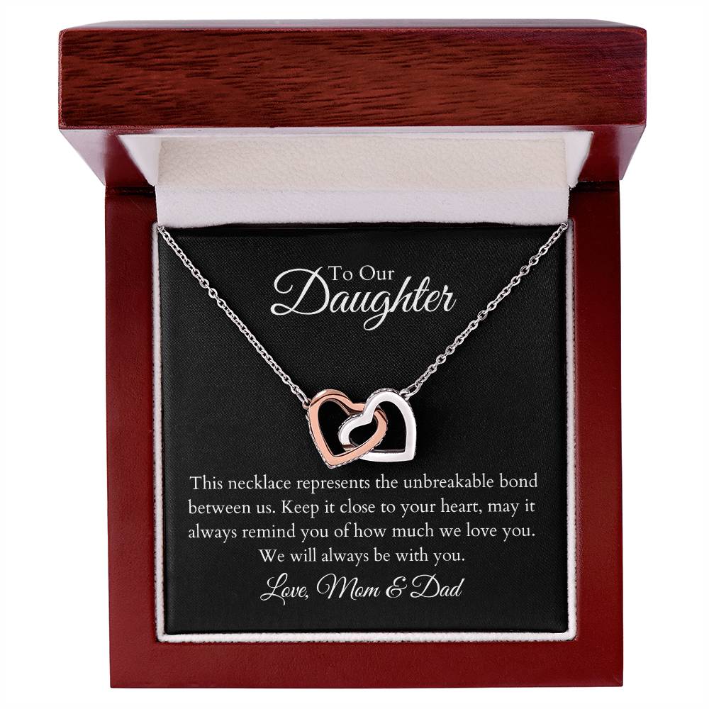 To Our Daughter, two lovely interlocking heart pendants embellished with CZ crystals. High quality polished surgical steel and rose gold finish. Love Mom & Dad