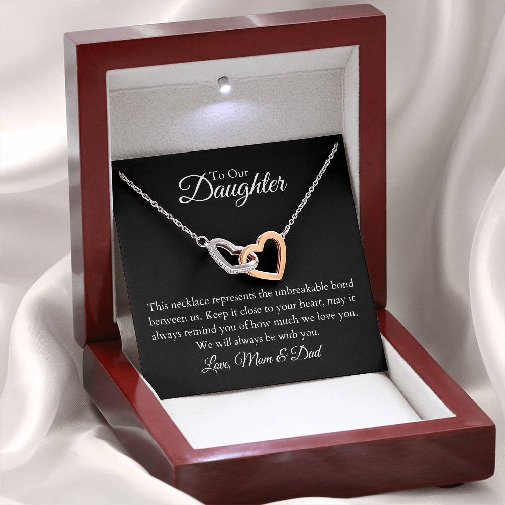 To Our Daughter, two lovely interlocking heart pendants embellished with CZ crystals. High quality polished surgical steel and rose gold finish. Love Mom & Dad